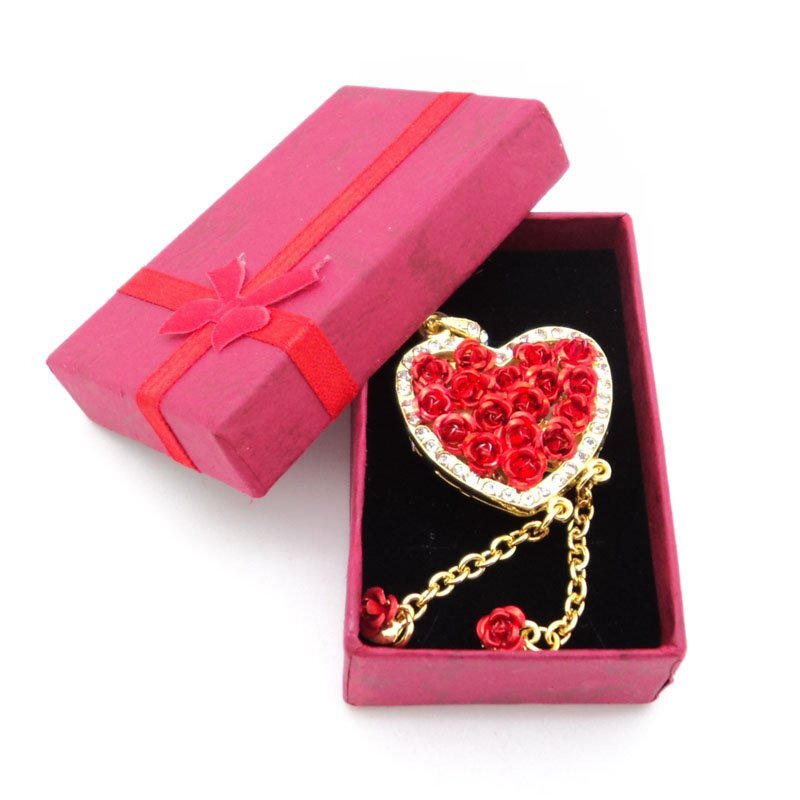 Scatola regalo gioiello con nastro magenta e ciondolo a cuore all'interno