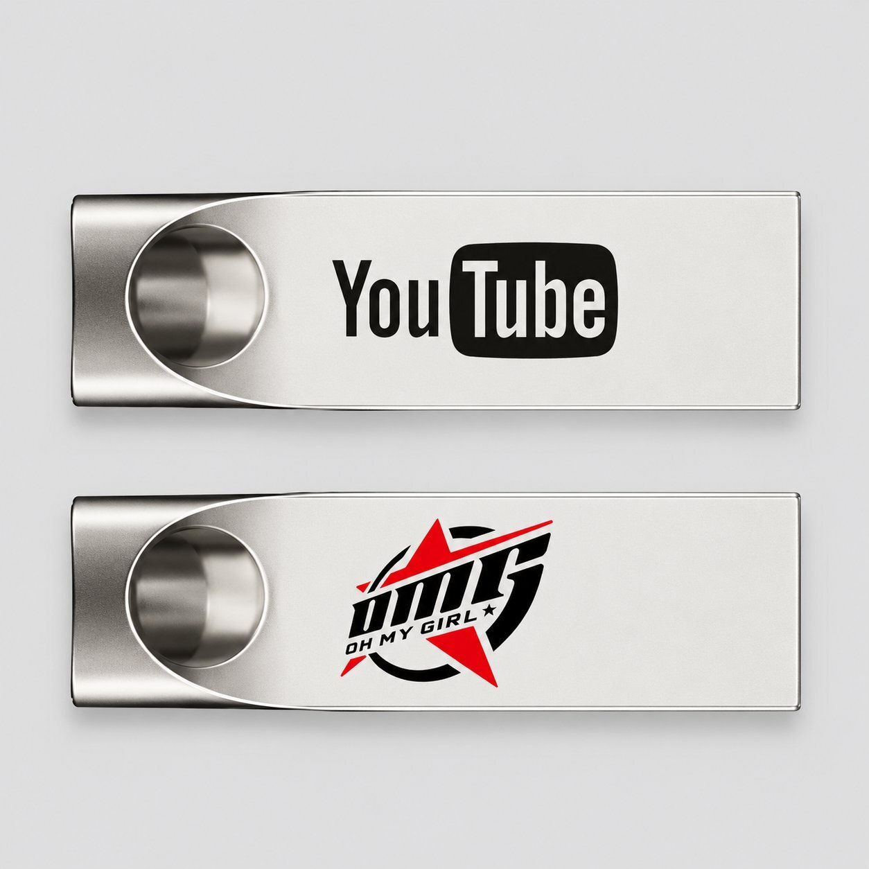 Two silver metal USB flash drives with circular cutouts at one end, one printed with the YouTube logo and the other with an OMG OH MY GIRL logo, showing how a buyer brand is reproduced on a metal USB using UV print and laser engraving.